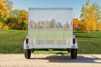 Rear view of a galvanized single-axle utility trailer with fold-down mesh tailgate, red tail lights, and tubular side rails.