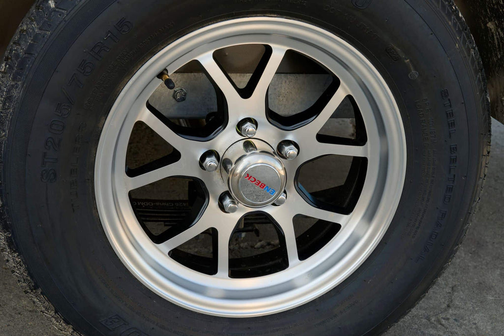 Close-up of single-axle cargo trailer wheel and tire.