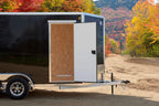 Black tandem-axle enclosed cargo trailer front side view.