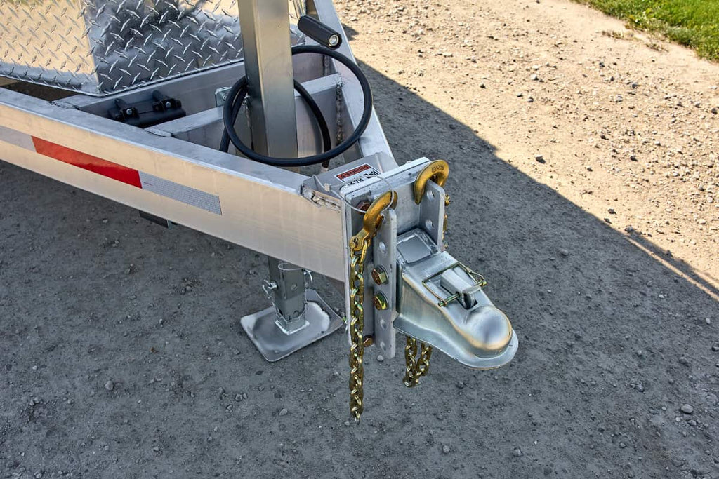 Close-up view of the A-frame tongue of a tandem 5200 lbs dump trailer, showing its hitch, wiring, and aluminum frame structure.