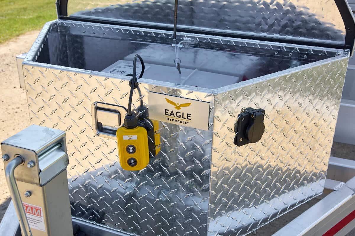 Close-up of open diamond-plate aluminum tongue box on a tandem 5200 lbs dump trailer.