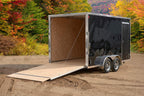 Black tandem-axle enclosed cargo trailer ramp down view.