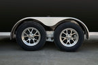 Black tandem-axle enclosed cargo trailer wheel shot.