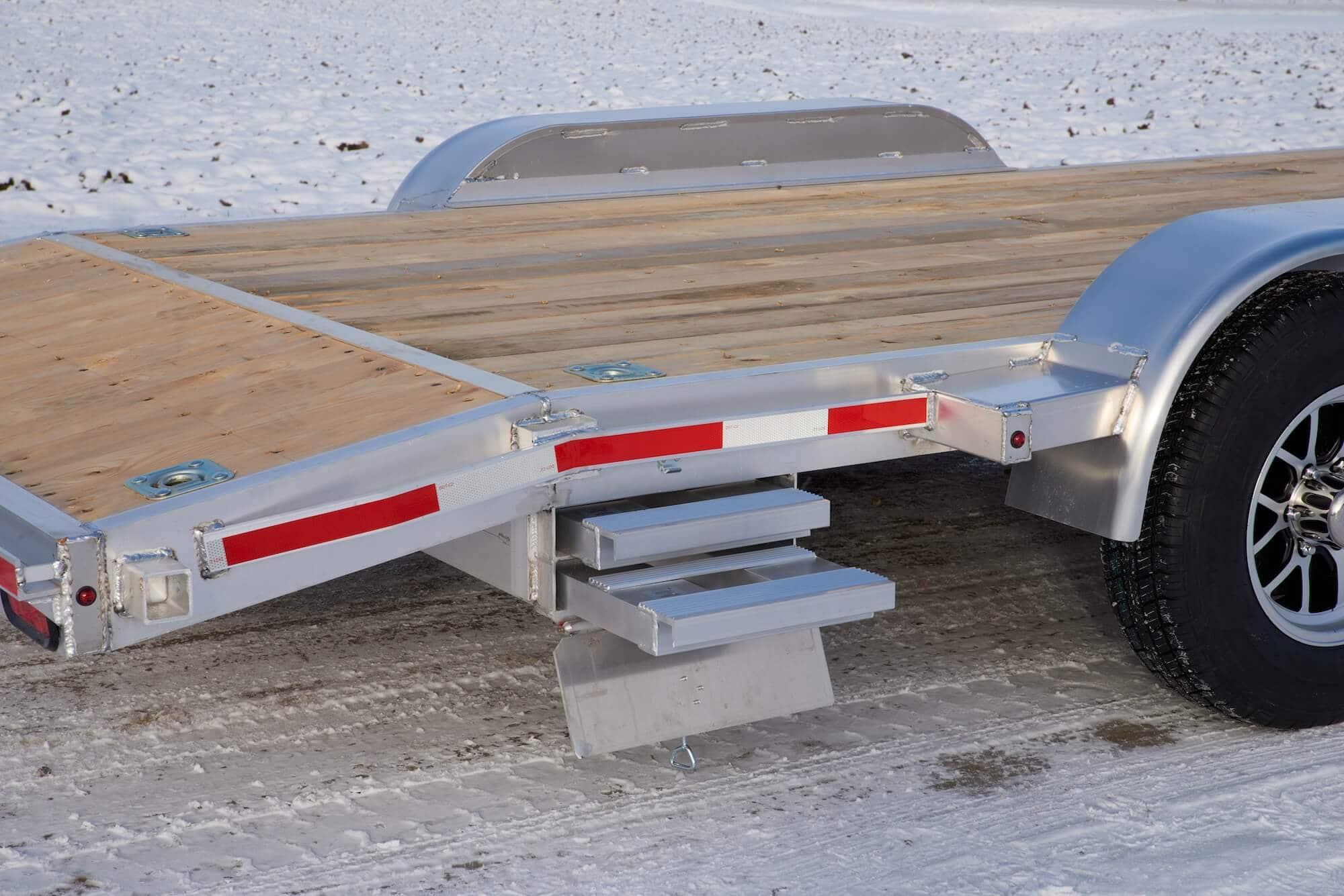 Tandem car hauler with ramp storage compartment open.