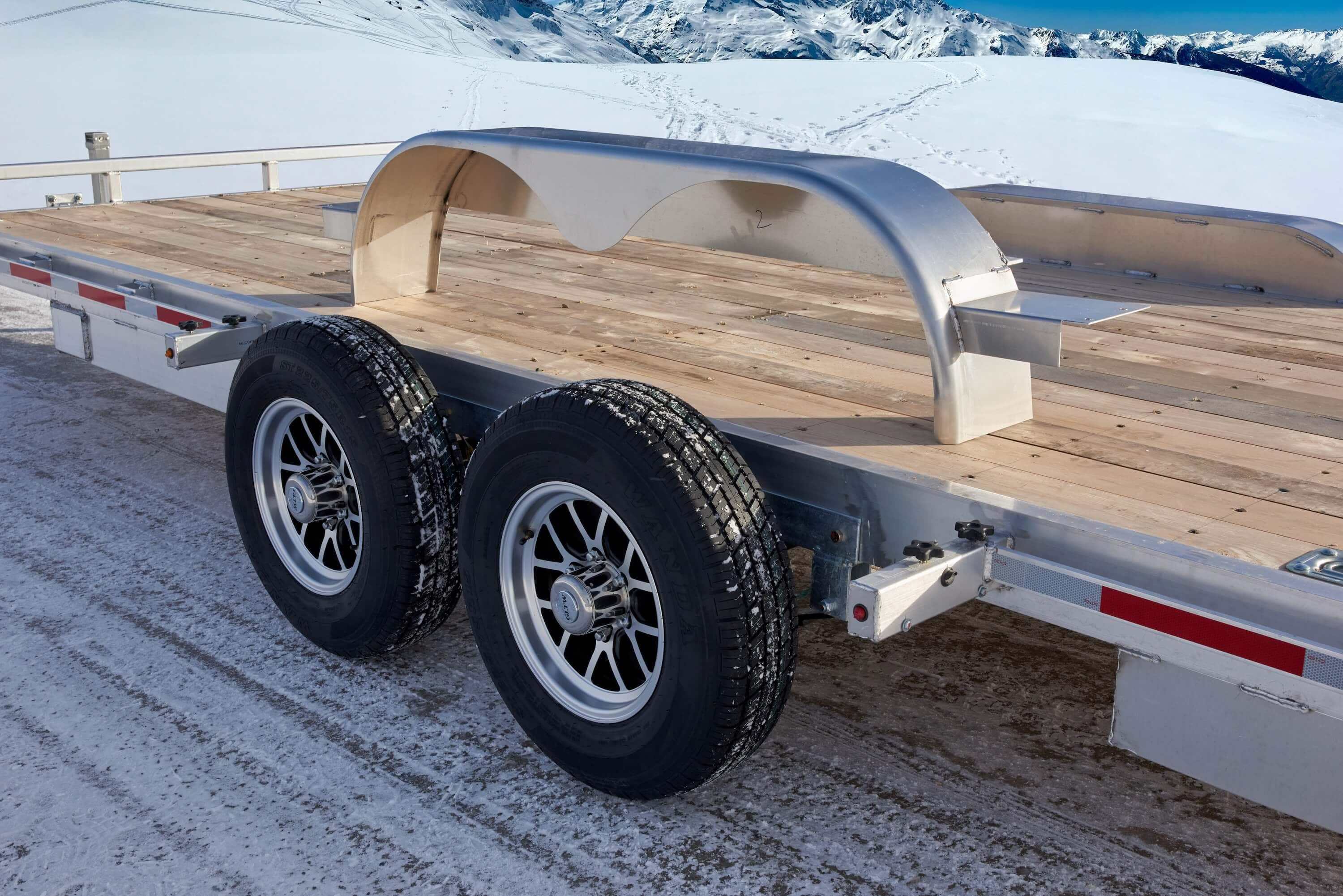 Tandem car hauler trailer with fender removed, showing exposed wheel area.