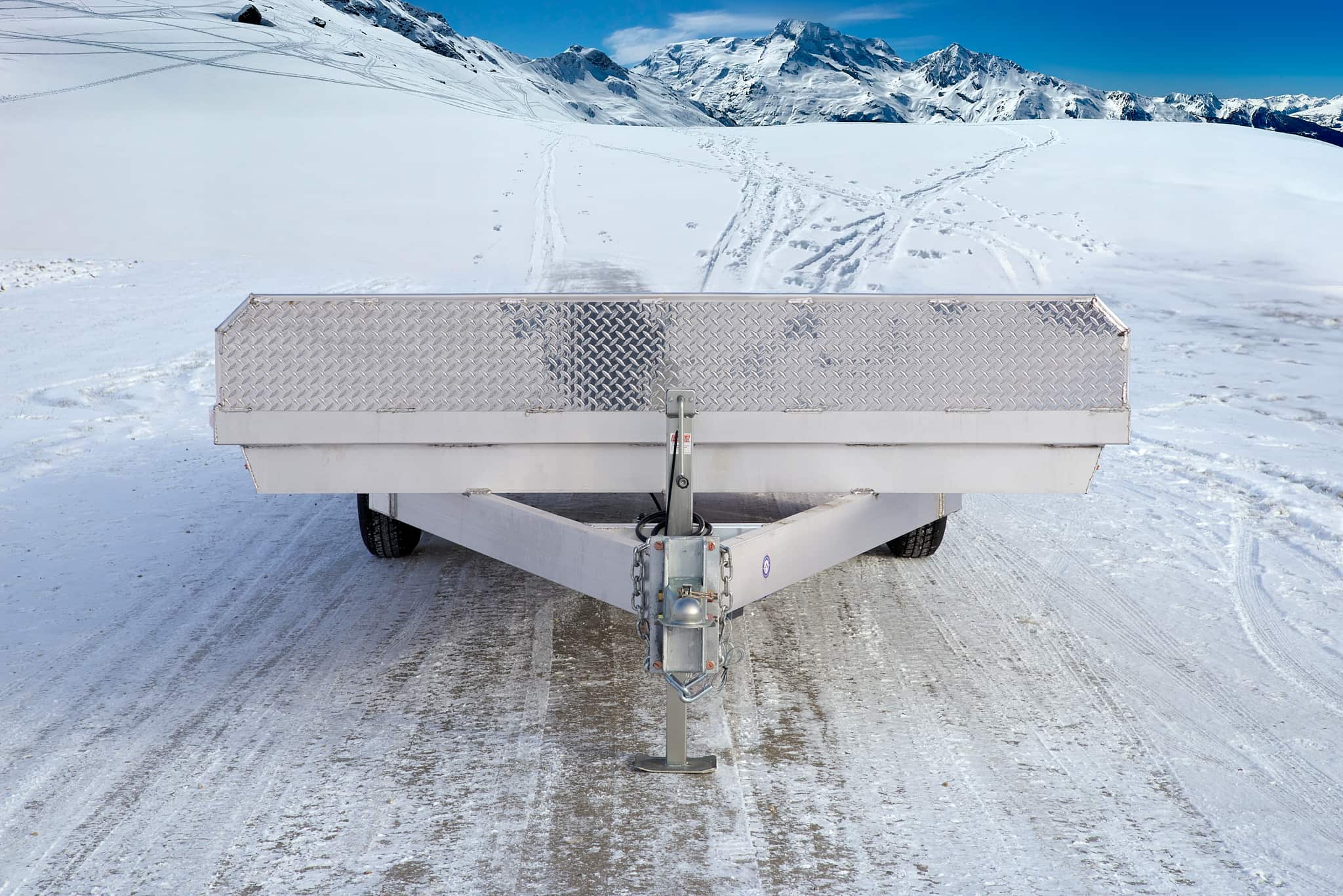 Tandem deckover wheel-under trailer viewed from the front.